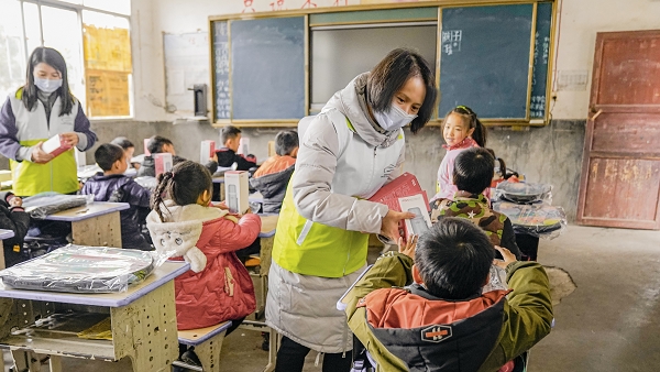 5-“绿动未来”志愿者为孩子们发放书包、保温杯等暖心物资.jpg